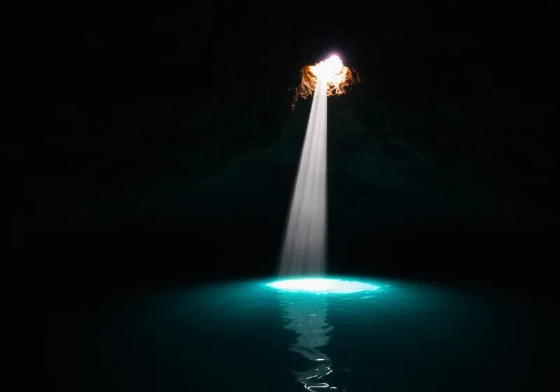 Hidden cave cenote with light beam